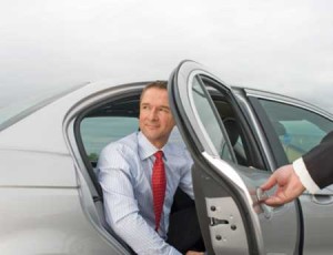 Chauffeur Opening Silver Car Door for Business Executive